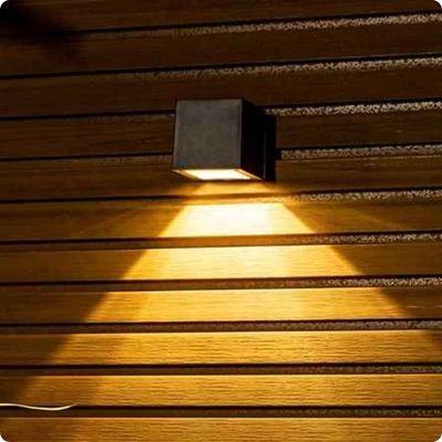 Applique exterieur solaire Cube éclairant une façade en bois