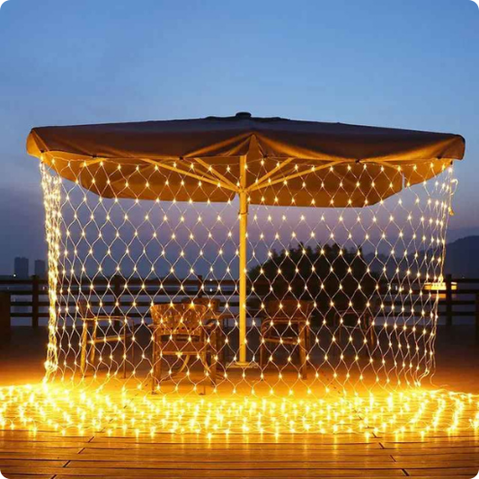Filet lumineux Maille blanc chaud entourant un salon de jardin