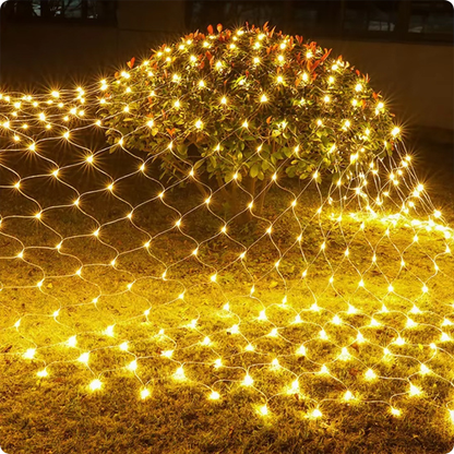 Filet lumineux maille blanc chaud décorant une plante