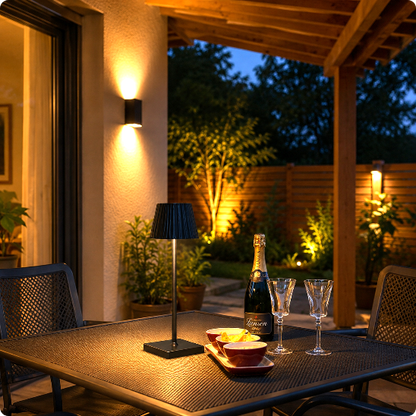Lampe de table Luma Touch noire éclairant une table pour l'apéritif