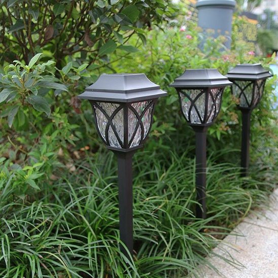 Lanternes solaires plantées dans des buissons