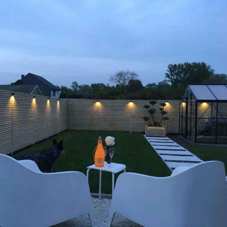 luminaire extérieur mural Orion éclairant une clôture